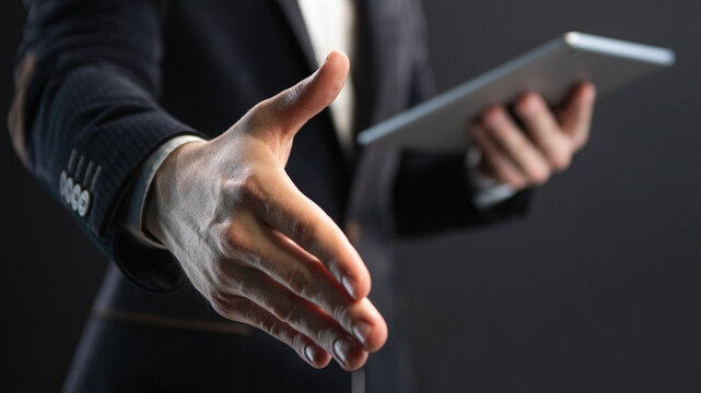 businessman holds out his hand for a handshake