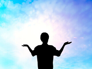 Fototapeta na wymiar 両手を上に向けて立つ男性シルエット_スピリチュアルな空背景