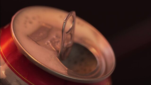 Closeup man hands open cans of cold beer on black background