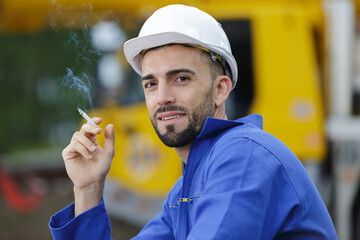 worker with hardhat on smoking