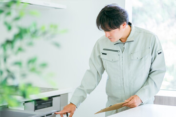 キッチンと作業着姿の男性（食洗機）
