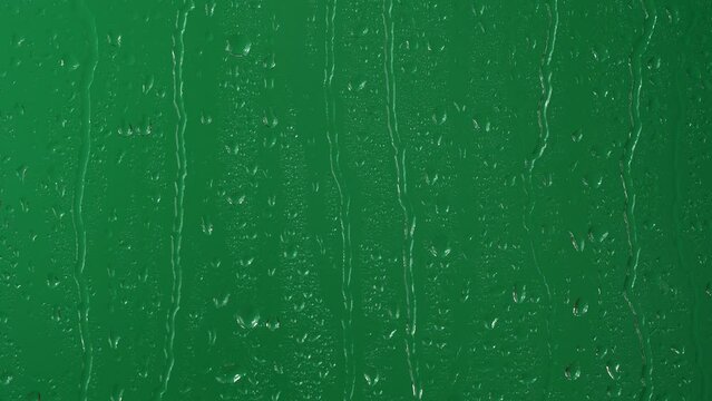 Water rainfall, rain drops falling on window glass over chroma key green screen