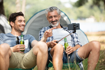 male friends having good time while camping