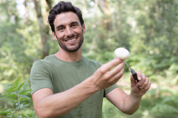 Naklejka na ściany i meble man found a white mushroom in the forest