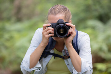 woman in rural setting looking through camera viewfinder