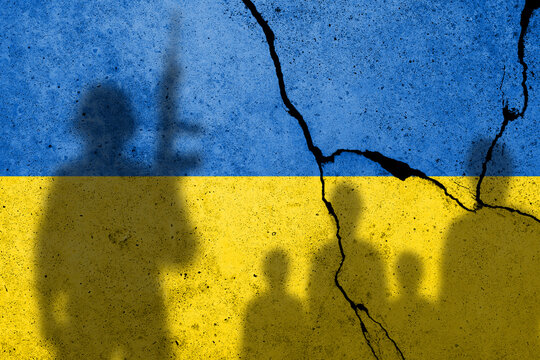 Flag Of Ukraine Painted On A Concrete Wall With Ukrainian Civilians And A Russian Soldiers Shadows. Russian Military Aggression