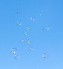 Soap bubbles fly against the sky.