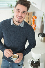 handsome man on kitchen drinking coffee in the morning