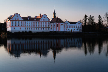 Fototapeta na wymiar Neuhaus Castle is reflected in the evening light on the surface of the Inn.