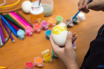 Obraz na płótnie Canvas Kid are painting Easter eggs. Preparing decorations for Easter, creativity with children, traditional symbols. Preparing for Easter.