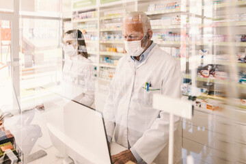 Pharmacy workers working on computers during corona virus.