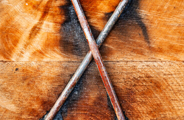 Two wooden beams fastened with steel bars cross to cross, close-up.