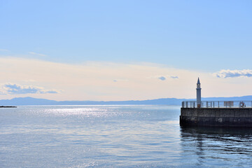 片瀬漁港の白い灯台と海面の太陽の輝き