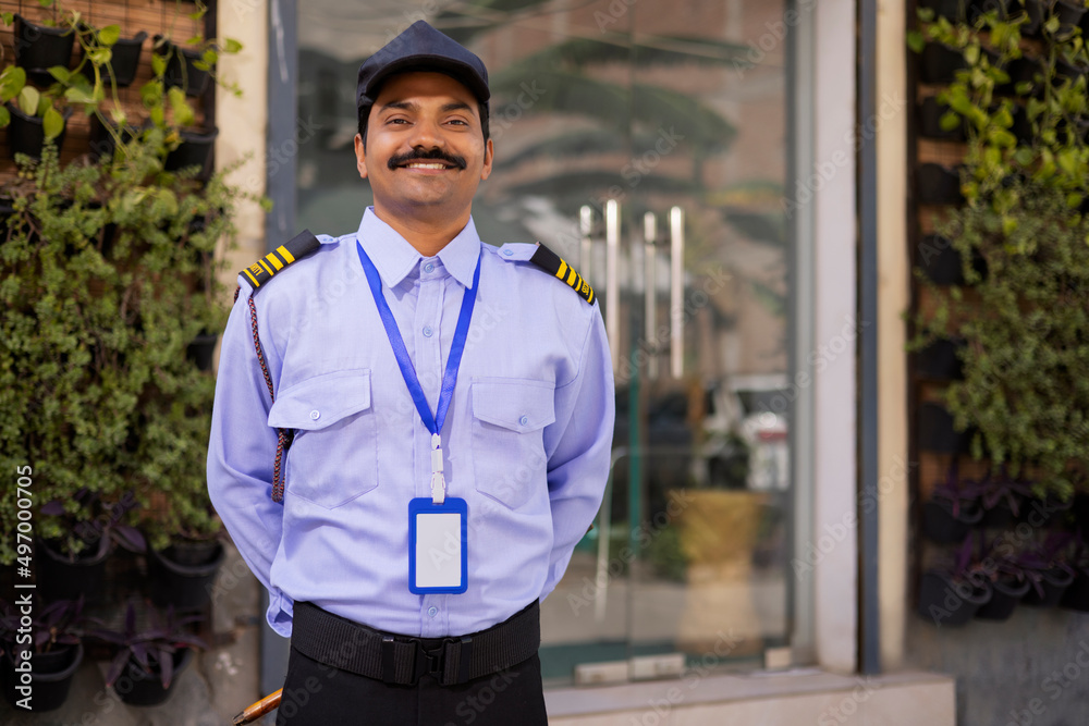Wall mural portrait of security guard with hands behind back while working at gate