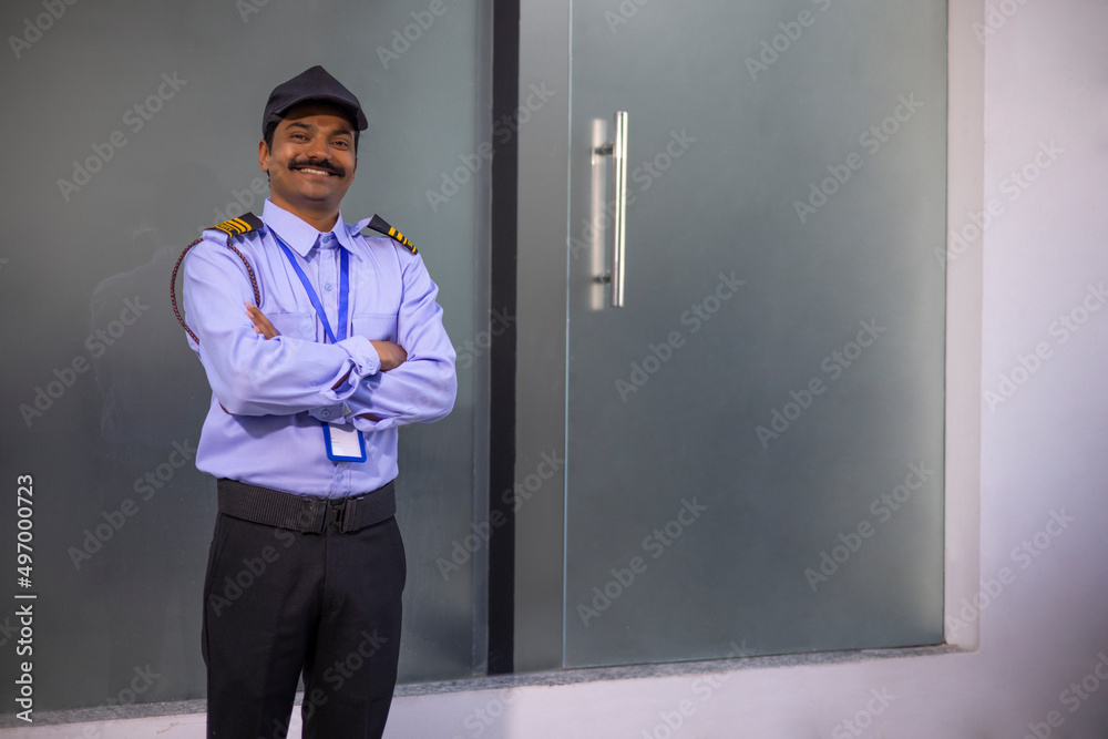 Wall mural portrait of security guard with arms folded while working at gate