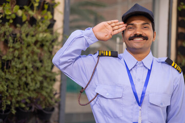 Portrait of a male security guard saluting