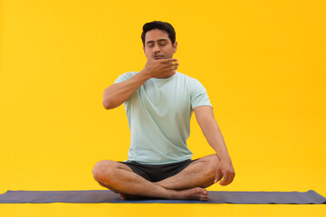 Portrait of a young man doing breathing exercise at home