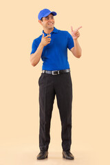 Portrait of a courier delivery boy pointing elsewhere with fingers