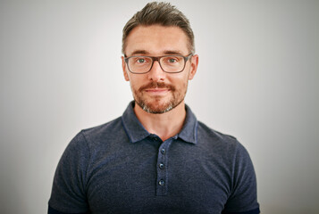 Confident and self-assured. Cropped portrait of a mature man standing against a gray background.