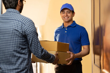 Young courier boy delivery parcels to customer at door