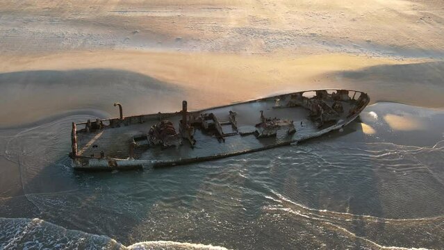 Aerial view of wrecked boat, on the shoreline , on the beach in Moshav Habonim old shipwreck in Habonim beach in Israel.