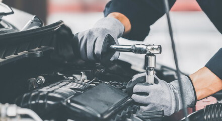 Mechanic works on the engine of the car in the garage. Repair se