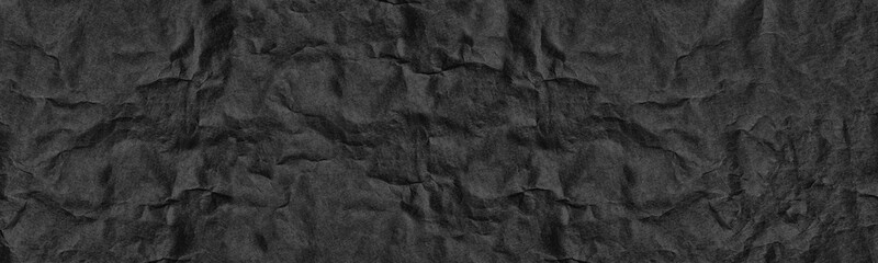 Black old crumpled paper wide panoramic texture. Wrinkled dark paper sheet surface. Abstract large banner vintage grunge background