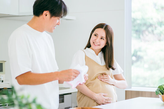 家事を手伝う男性と妊婦（皿洗い）
