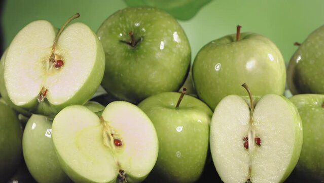 Slow Motion Shot of Green Apple Juice Splashing through Apple Slices