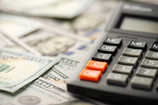 Close up photo of calculator and dollar banknotes