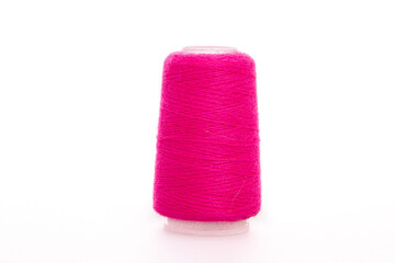 Pink spool of thread isolated on white background. Skein of woolen threads. Yarn for knitting. Materials for sewing machine. Coil