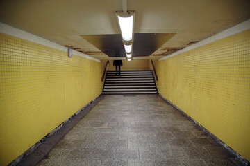 Pedestrian subway leading to Underground Trains in Berlin. Run-down, retro styled with converging Lines and fluorescent lighting.