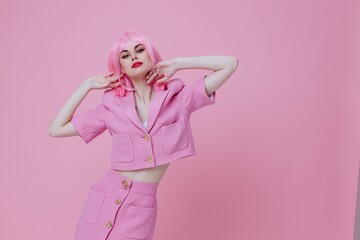 Pretty young female gestures with his hands with a pink jacket pink background unaltered