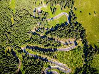Winding road from high mountain pass, in summer time. Aerial view by drone. Romania
