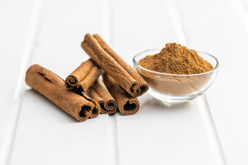 Dry cinnamon sticks and cinnamon powder on white table. Cinnamon spice.