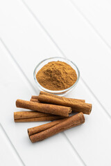 Dry cinnamon sticks and cinnamon powder on white table. Cinnamon spice.