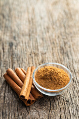 Dry cinnamon sticks and cinnamon powder on wooden table. Cinnamon spice.