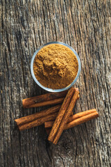 Dry cinnamon sticks and cinnamon powder on wooden table. Cinnamon spice.
