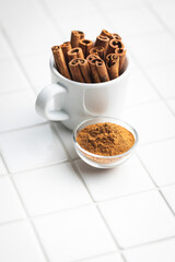 Dry cinnamon sticks and cinnamon powder on kitchen table. Cinnamon spice.