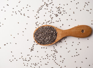Healthy chia seeds in a wooden spoon on the table close-up