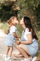 family, motherhood and people concept - happy mother and daughter hugging and kissing