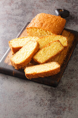 Sliced Madeira Cake closeup on a wooden cutting board on the table. Vertical