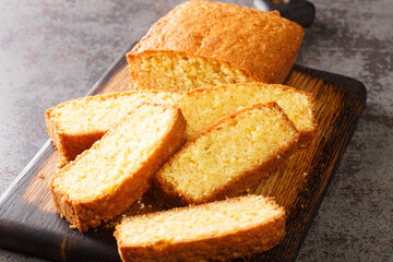 Madeira loaf cake closeup served on a wooden cutting board on the table. Horizontal