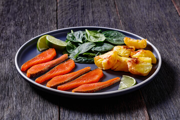 salmon slices with spinach leaves, roast potatoes