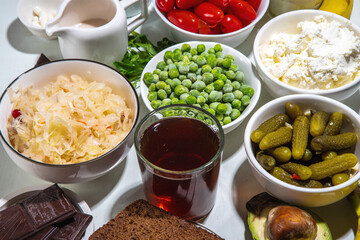 Postbiotic, prebiotic and probiotic food with medicine capsules. Set Super Healthy Fermented Food Sources, drinks, ingredients, on white marble background copy space top view