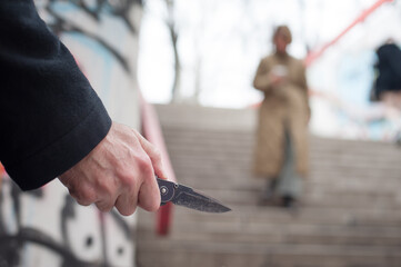 Hidden maniac robber with knife in ambush attacks female victim