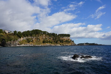 Fototapeta na wymiar island and clouds view from seaside cliff