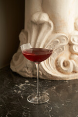Red cocktail glass on a marble bar counter