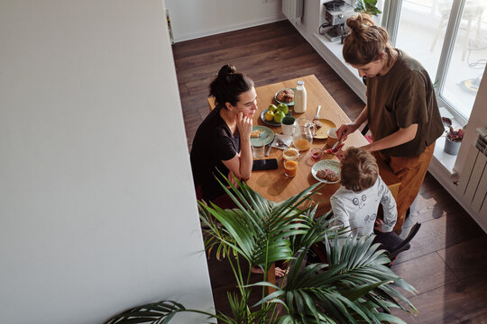 High angle view of lesbian family having breakfast at table with their little son
