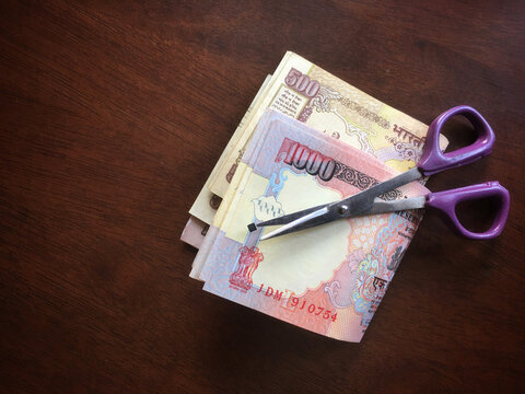 Five hundred and thousand rupee old Indian currency notes with scissor. An idea.